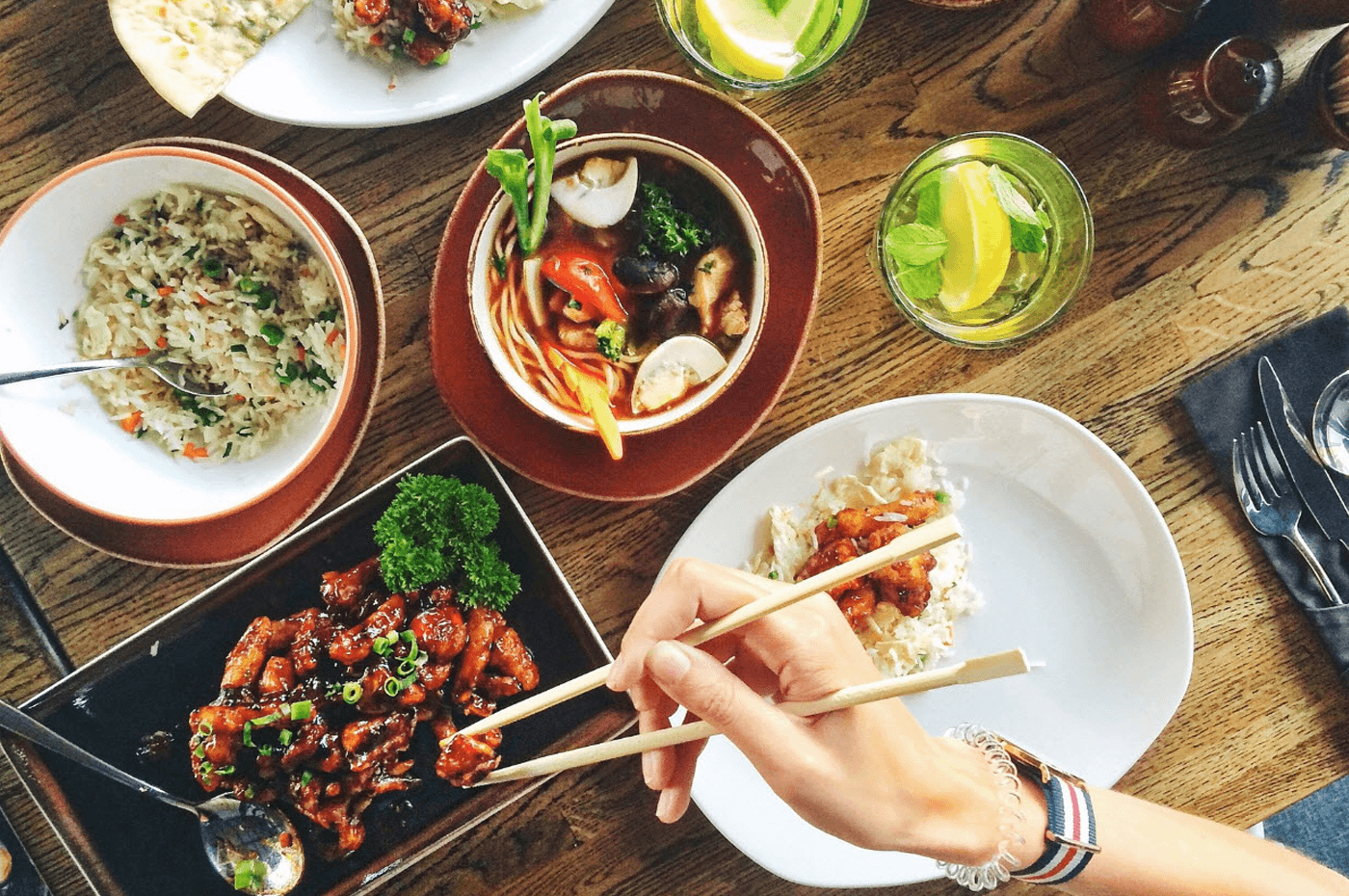 Restaurant table featuring small plates of asian fusion food.