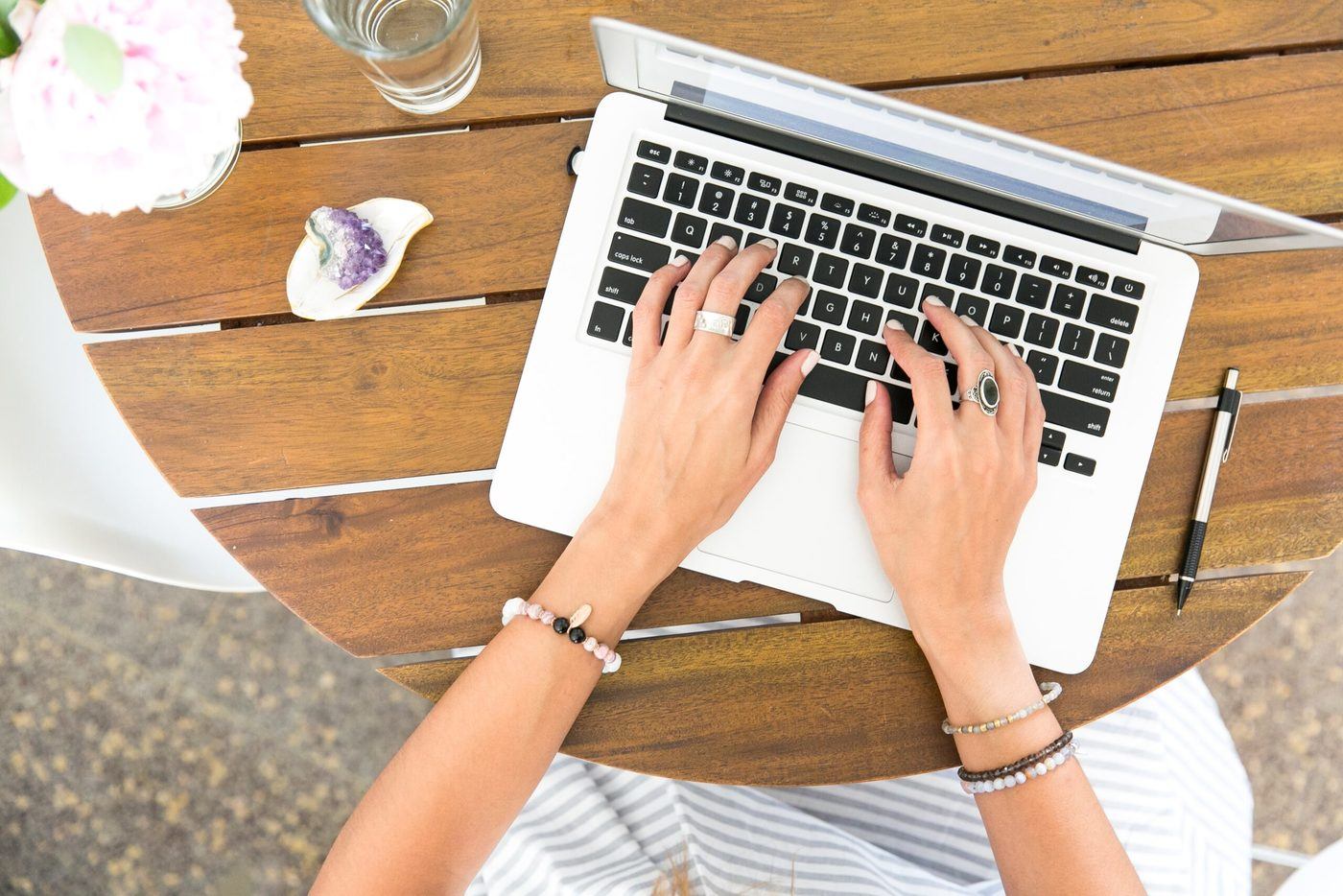 women typing on laptop keyboard