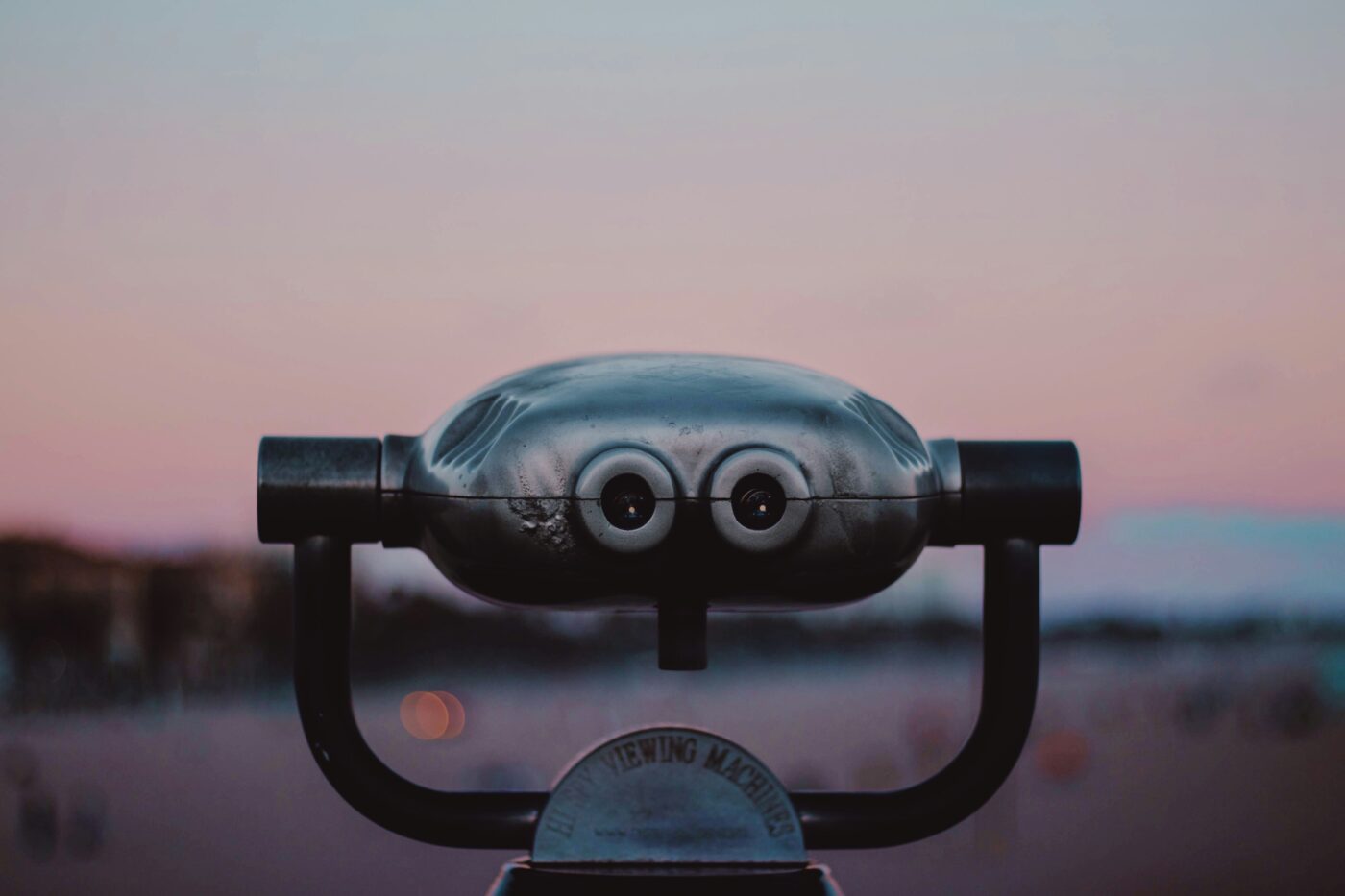a pair of binoculars on a stand where the viewfinders look like eyes so that it looks like a robot.