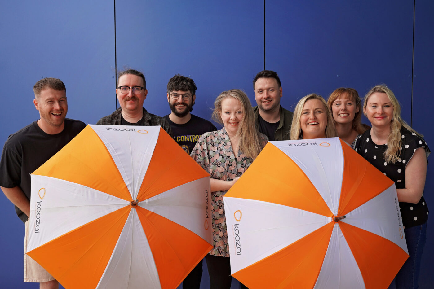 Koozai team outside with Koozai branded umbrellas